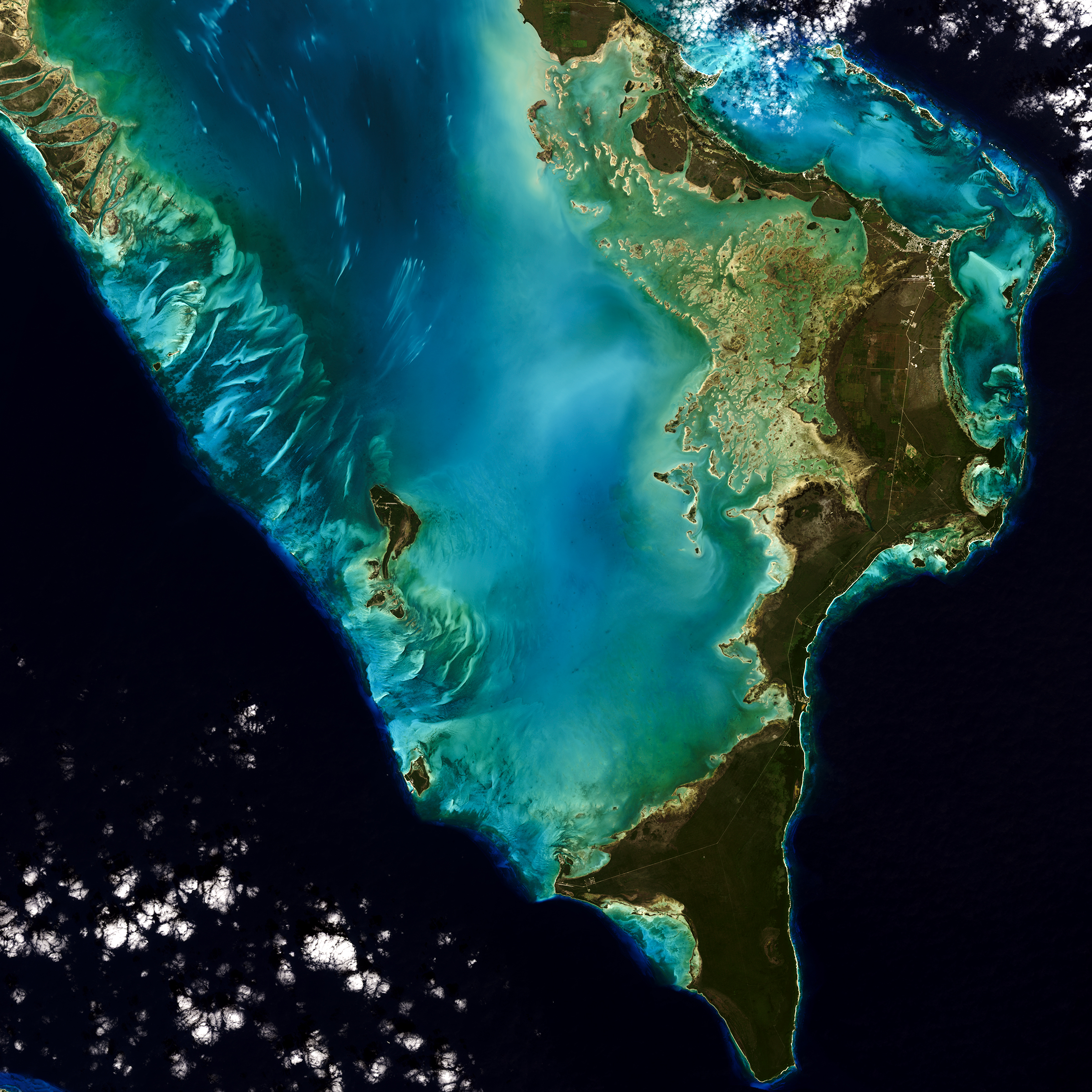 satellite image of Bahamas with teal shallow waters surrounded by dark blue ocean