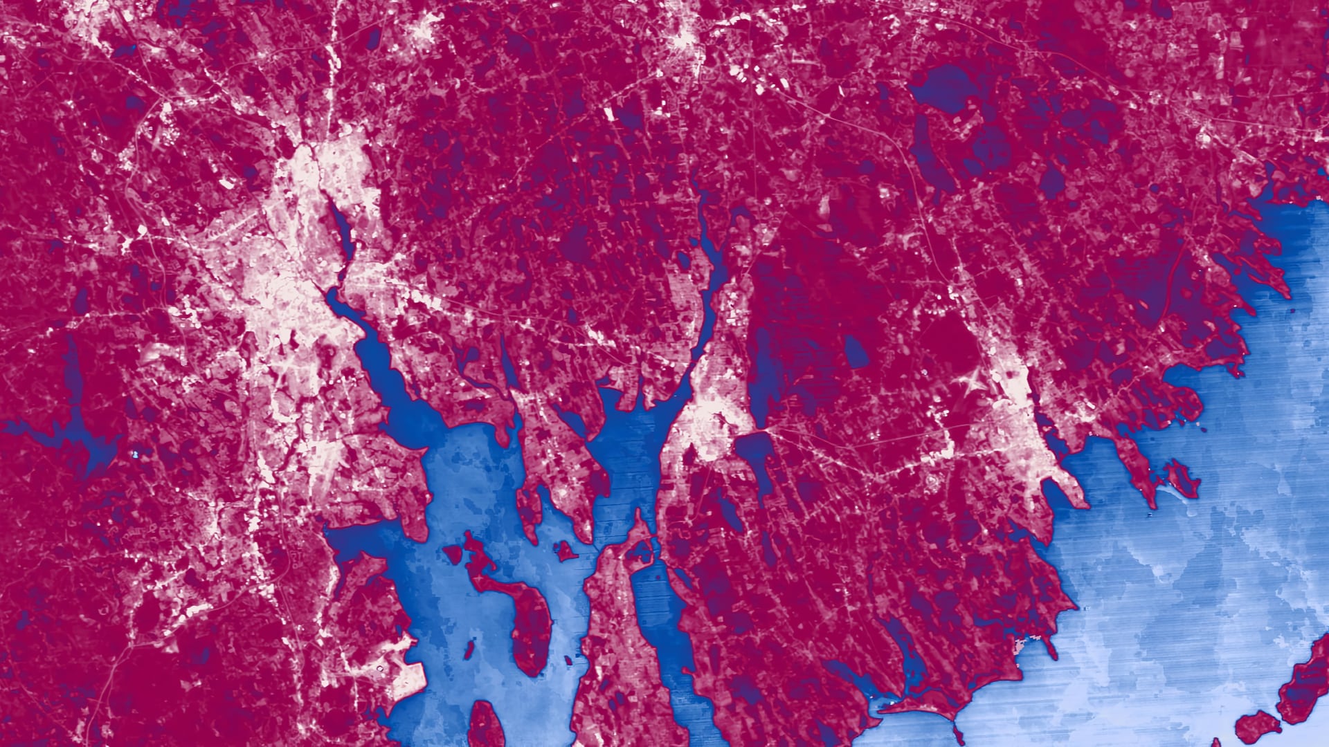 Land surface temperature averages for 2014 through 2018 derived using the new Landsat Level-2 Provisional Surface Temperature product (Landsat 7 ETM+ and Landsat 8 OLI). This image is focused on Providence, RI, and was used to assess urban heat within the city. Higher surface temperatures appear lighter pink; lower surface temperatures appear deeper pink. The blue areas represent the water surrounding the area.