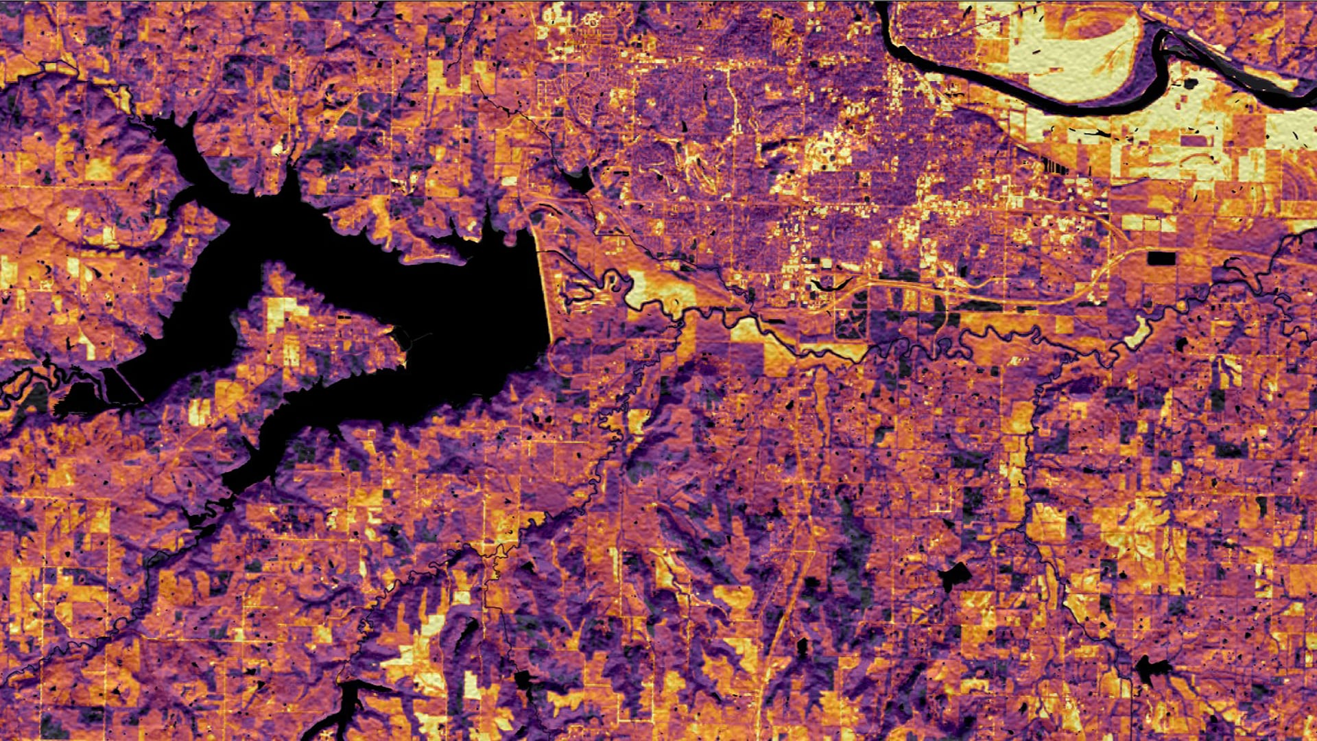 A 30-meter resolution map from a 4/26/2019 Landsat 8 OLI image with a tasseled cap brightness transformation overlaid on a solar insolation map derived from a 9/23/2014 DEM created with the SRTM C-Band. Lawrence, Kansas, is featured here. Bright yellow signifies areas with high surface reflectance, indicating bare soil and rooftop areas ideal for solar panels. Darker purple signifies areas of low surface reflectance, indicating forest and wetland locations not ideal for solar panels.