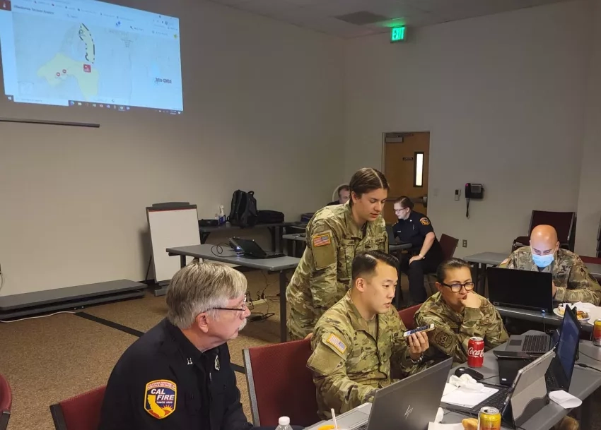 photo of people in military garb in a room looking at computers