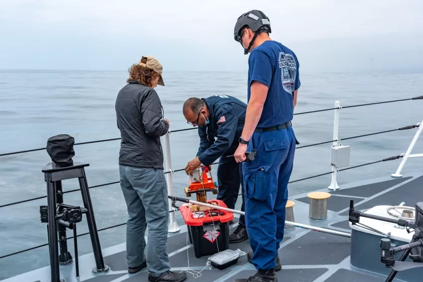 Equipment being readied to study a naturally occurring oil spill on the desk of the U.S. Coast Guard cutter Blackfin on May 10, 2021. Taking part in this MOST field test are, (l to r), the Coast Guard's Dana Tulis, Director, Incident Management and Preparedness Policy; Oscar Garcia-Pineda of Water Mapping LLC, and a Blackfin crewmember Credits: NASA/University of Maryland/Frank Monaldo