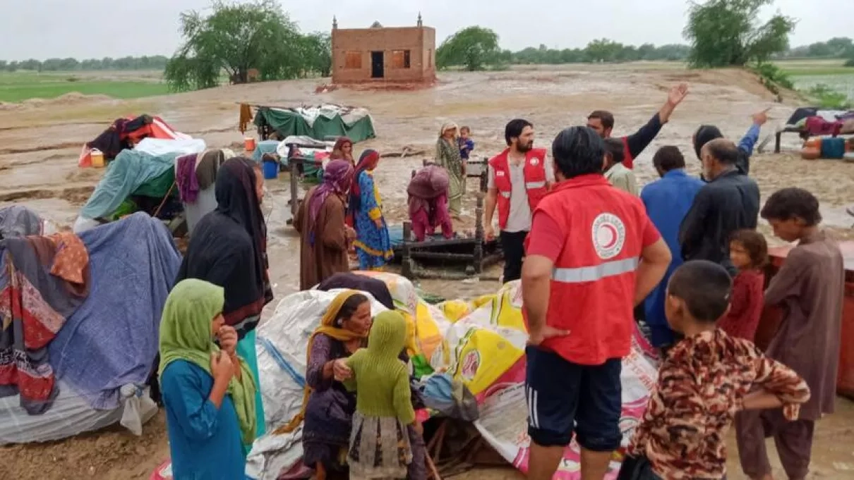 Photo of humanitarian workers providing aid to residents of a flooded village in Pakistan. 
