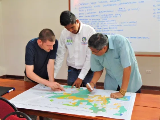 Scott LaRocca (University of Richmond), Luis Felipe Aguilar Arias (the Ucayali Regional Environmental Authority), and Pedro Tipula (the Panamerican Institute of Geography and History) discuss annotations on one of the maps created during the workshop. Credits: Jacob Ramthun, NASA