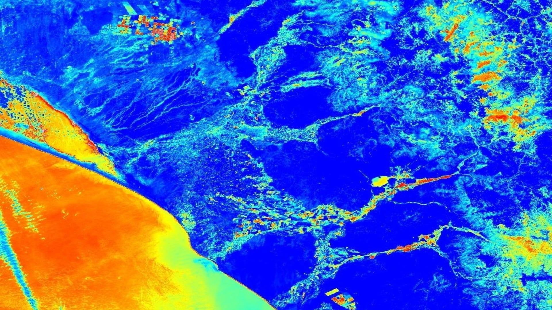 The Landsat 8 satellite and the Operational Land Imager sensor. The image displays the Normalized Difference Water Index, demonstrating water stress on vegetation. The area shows Northwestern Peru and the Pacific Ocean. The data was obtained through Google Earth Engine and processed manipulating the sensitivity, and classifying by color. The scale ranges from blue - red. Dark Blue areas maintain higher water stress levels and areas with a red  hue represent a lower water stress level.  Keywords: Rivers, Agriculture, Lambayeque, Chiclayo, Mesquite Algarrobo