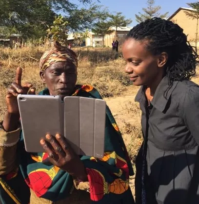 Photo of scientist showing iPad data to a Ugandan expert