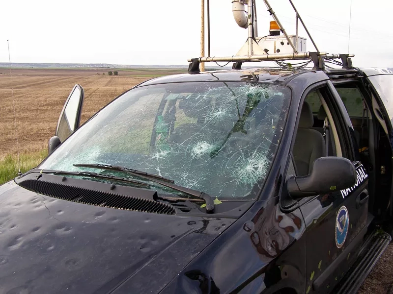 Car with damage to hood and windshield by hail