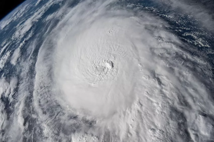 Photograph of Hurricane Milton from space, appearing as a large white swirling mass of clouds.