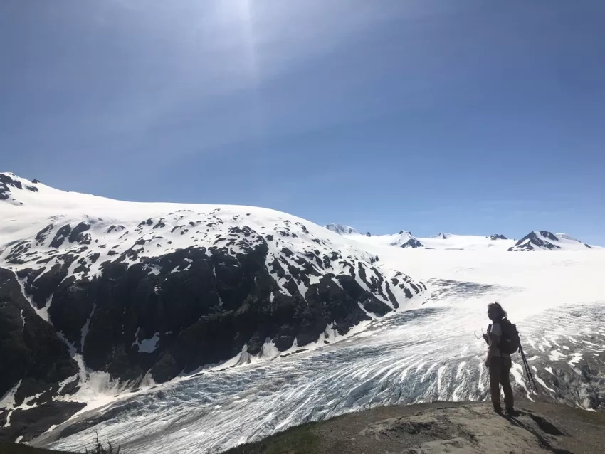 Photo of person in front of glacier