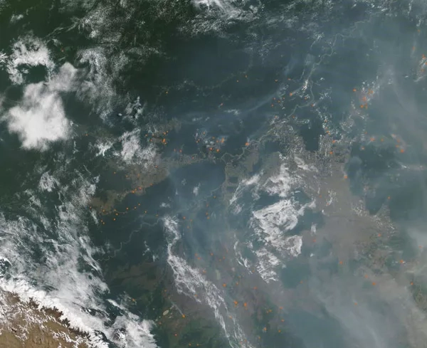 On September 3, the Moderate Resolution Imaging Spectroradiometer (MODIS) on NASA’s Terra satellite acquired this true-color image of smoke and fire near the border of Bolivia and Brazil. Numerous hot-spots, shown in red, mark areas where the thermal bands on the instrument detected high temperatures. When combined with typical smoke, as in this image, such hot spots mark actively burning fire. Credit: MODIS Land Rapid Response Team, NASA GSFC
