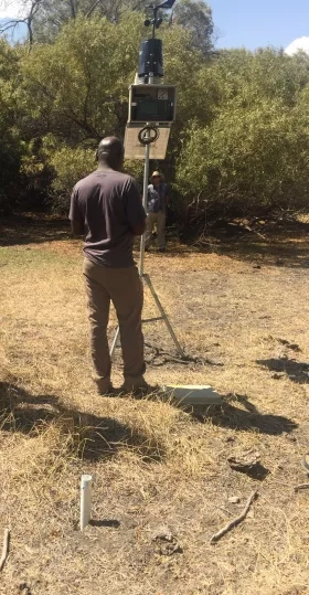 man setting up a tall metal tool outdoors