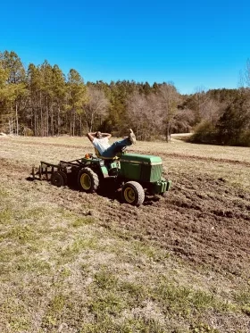 This picture shows one of the project partners, Demetrius Hunter, riding a tractor on his 60-acre farm in Norlina, North Carolina. Demetrius is a sixth-generation black farmer and aggregator who sources agricultural products from other black farmers and sells them at his two grocery stores, The Black Farmers Hub in Raleigh and Peanut and Zelb’s in Norlina.