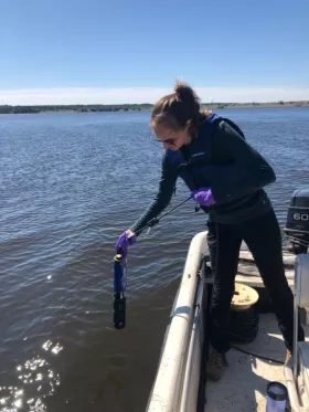 Woman on lake installing science instruments