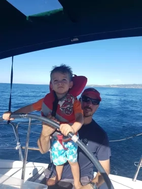 Photo of man on boat with kid and fish