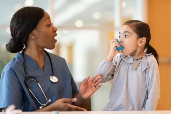 photo of a nurse helping a child with a breathing device