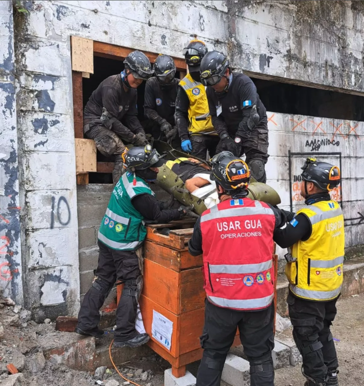Un equipo de búsqueda y rescate urbano (USAR) de la Coordinación Nacional para la Reducción de Desastres de Guatemala (CONRED) simula rescatar a un individuo atrapado de una estructura colapsada durante la 3ª Simulación Regional de Respuesta a Desastres y Asistencia Humanitaria. Créditos: CEPREDENAC