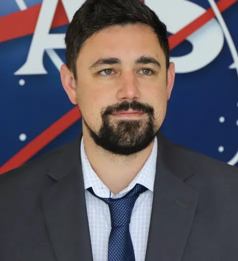 Jonathan pictured standing in front of the original NASA logo