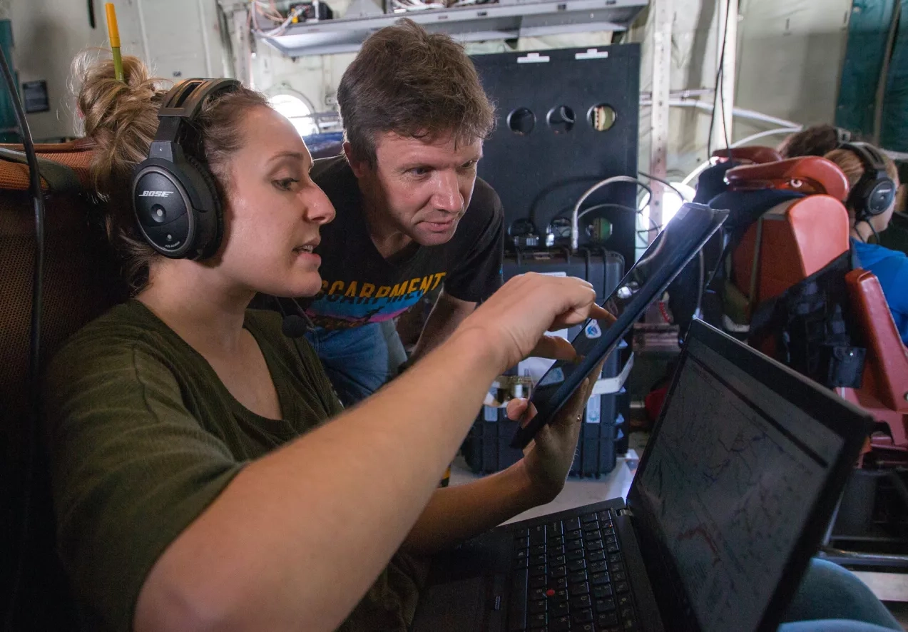 Bianca Baier, a postdoctoral researcher with NOAA’s Earth Systems Research Lab in Boulder, Colorado, and Ken Davis, ACT-America principal investigator from Penn State, talk during a flight. 