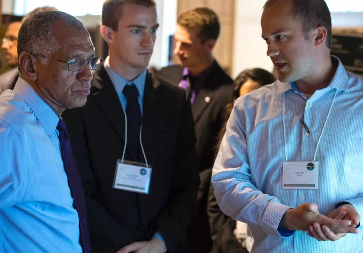 NASA Administrator Charles Bolden speaks with young professionals about their project during the annual DEVELOP Earth Science Application Showcase