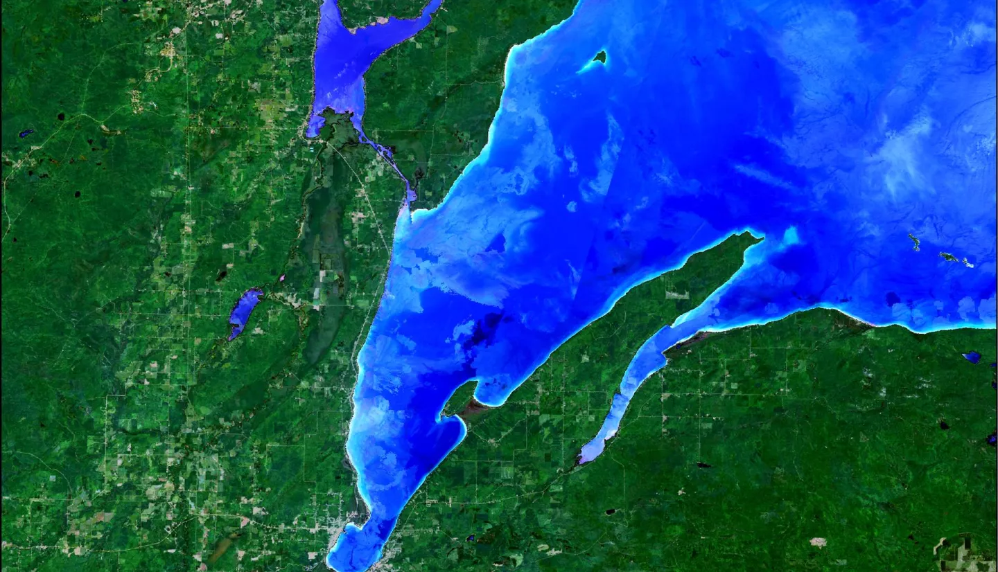 NDTI-processed imagery from Landsat 8 OLI data.  This image from October 2021 depicts the turbidity of Keweenaw Bay, western Michigan coastline of Lake Superior.  Light blue-colored water indicates greater turbidity while darker blue water is less turbid.  Turbid waters indicate coastal erosion and re-distribution of legacy copper mining waste colloquially referred to as "stamp sands".  Stamp sands contaminate wetlands and threaten traditional food sources for Indigenous communities along the bay.