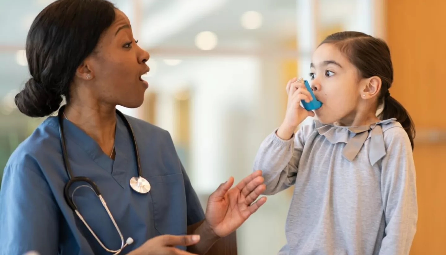 photo of a nurse helping a child with a breathing device