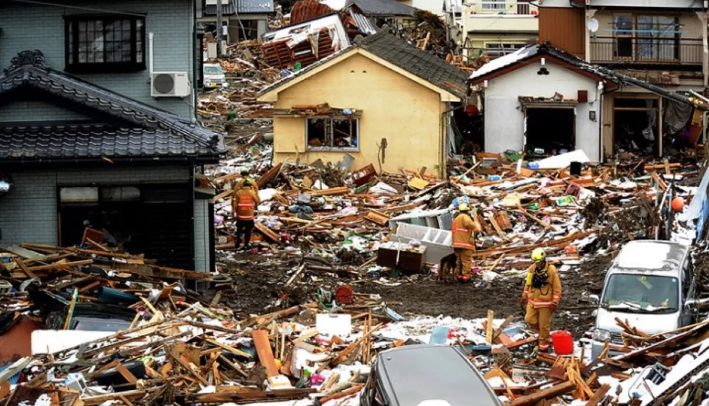 USAID firefighters are seen climbing through debris and crumbled buildings in Japan.