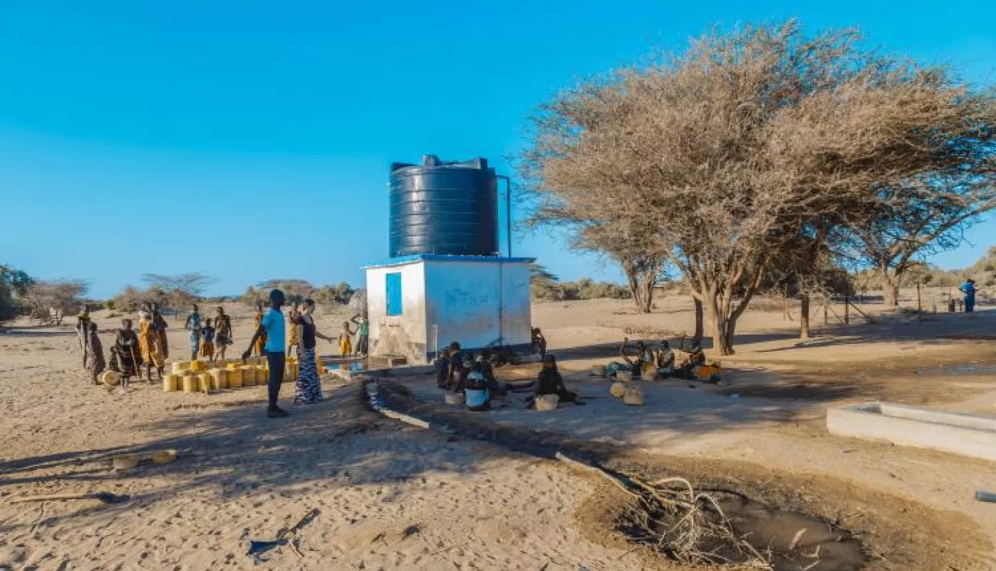 group of people near a groundwater pump