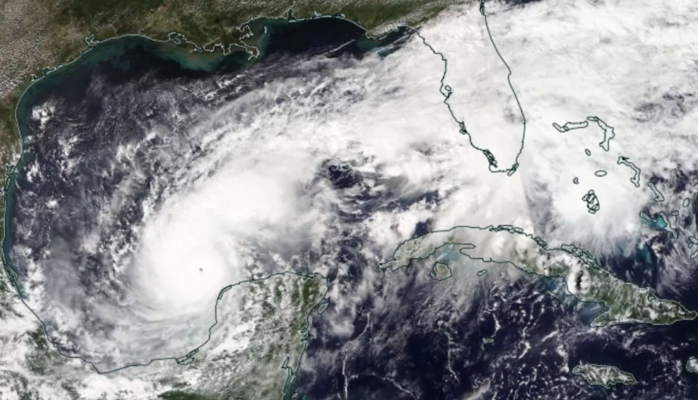 A satellite map of Hurricane Milton in the Gulf of Mexico, a large swirling mass of white clouds. 