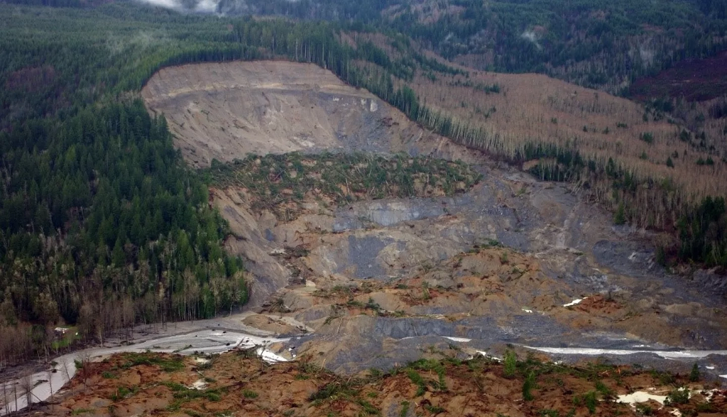 This photograph from an aerial survey shows the upper parts of the 2014 Oso landslide in northwest Washington. NASA’s landslide inventory documents events such as this one to improve model validation. Credits: Jonathan Godt, USGS