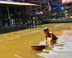 photo of boy swimming in river in Cambodia