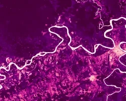 NDVI image displaying diverse land uses around Puerto Maldonado, Peru. Derived from Landsat 8 OLI, the image is a cloud-removed, composite mean from all available images over the 2020-2021 Peruvian wet season (October – April). Light pinks indicate low photosynthetic activity, and dark pinks and purples indicate high photosynthetic activity. These NDVI data inform land use analyses, which can assist public health and environmental officials in understanding the relationship between land cover and zoonotic d