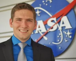 Josh Kelly standing near NASA logo