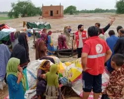 Photo of humanitarian workers providing aid to residents of a flooded village in Pakistan. 