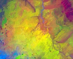Color composite image portraying Wupatki Basin in northwestern Arizona, derived from 2021 LANDSAT 8 OLI/TIRS imagery. This image depicts Pinyon-Juniper Woodlands (PJW), among other vegetation, between the river and mountains in a light green color. Thermal Infrared (TIR) occupies the red band, while the green and blue bands represent the Modified Normalized Difference Water Index (MNDWI) and the Modified Soil-Adjusted Vegetation Index (MSAVI), respectively. The reduced correlation between bands in this comp