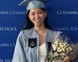 Molly smiles dressed in her graduation attire from Columbia University.