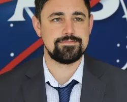 Jonathan pictured standing in front of the original NASA logo