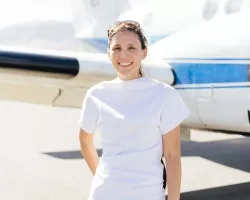 Photo of Melissa in white T-shirt in front of a small NASA branded plane