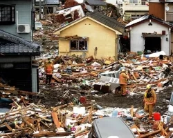 USAID firefighters are seen climbing through debris and crumbled buildings in Japan.