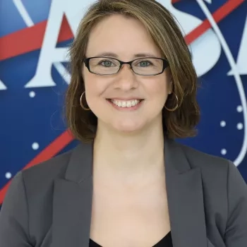 Photo of Melanie standing in front of the original NASA Logo