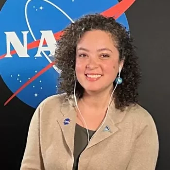 Natasha Sadoff pictured in front of a black backdrop with the NASA logo